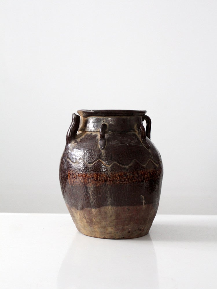 Rustic Glazed Pottery Water Pitcher 9 Inch Tall: Rustic Glazed Pottery Water Pitcher 9 Inch Tall This antique water pitcher features a rustic design crafted from glazed pottery in a deep brown hue. It is highlighted by a slender spout and distinctiv