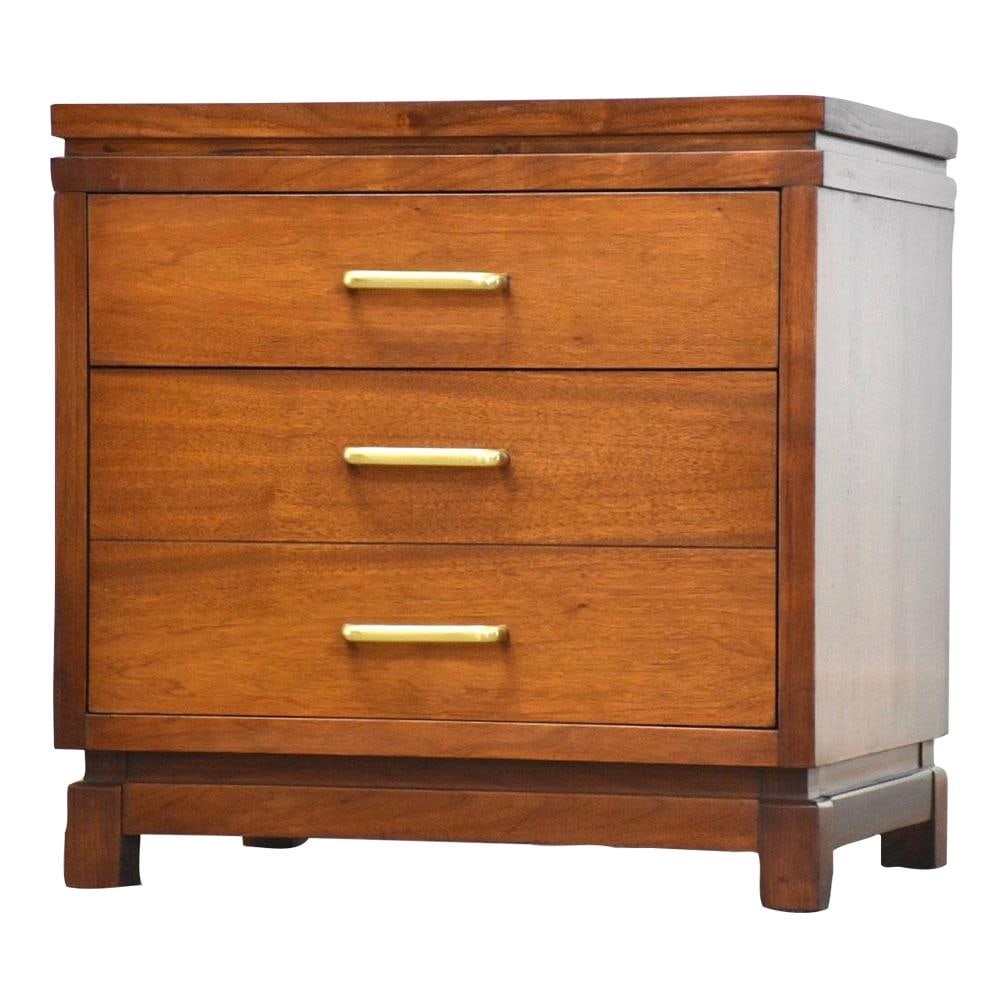 Mid Century Modern Ramseur Walnut Nightstand with Brass Pulls: Mid Century Modern Ramseur Walnut Nightstand with Brass Pulls This mid-century modern nightstand by Ramseur Furniture features a sleek walnut finish and two spacious drawers adorned with elegant brass