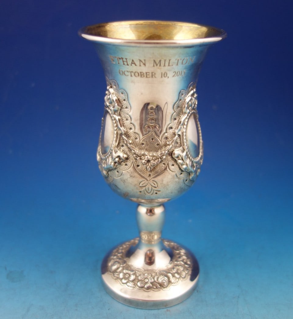 Sterling Silver Judaica Seder Cup with Repousse Wreath and Floral Detail 6 Inch: Sterling Silver Judaica Seder Cup with Repousse Wreath and Floral Detail 6 Inch This sterling silver Judaica Seder cup features a gold washed interior and is decorated with repousse and applied wreath