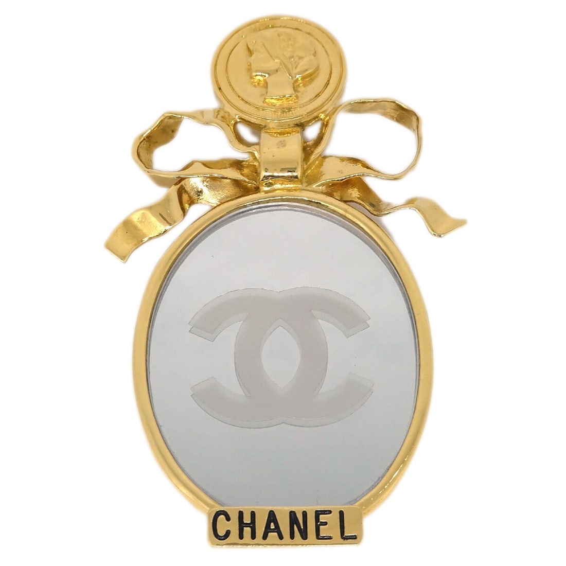 CHANEL gold plated bow mirror motif brooch pin: CHANEL gold plated bow mirror motif brooch pin Chanel brooch pin with a bow and mirror motif in gold-plated metal. This piece is presented in very good condition with noted scuffs and includes the box