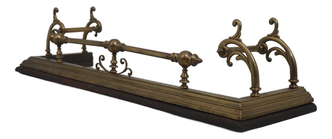 Victorian Brass Fireplace Fender with Scroll and Finial Detailing on Wood Base: Victorian Brass Fireplace Fender with Scroll and Finial Detailing on Wood Base This antique English fireplace fender features high-quality brass construction with a reeded and bobbin-shaped design, co