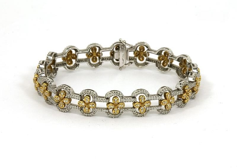 18k Two Tone Floral Link Bracelet with Diamonds: 18k Two Tone Floral Link Bracelet with Diamonds This exquisite two-tone bracelet combines the elegance of 18k white and yellow gold with the brilliance of round-cut diamonds. The ornate floral link de