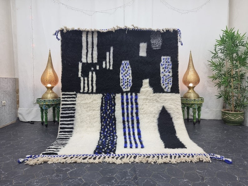 Authentic Handmade Moroccan Berber Wool Rug 9.84 x 6.56 ft: Authentic Handmade Moroccan Berber Wool Rug 9.84 x 6.56 ft Transform your living space with this stunning handmade Moroccan Berber area rug. Featuring an abstract design in white, black, and blue, thi