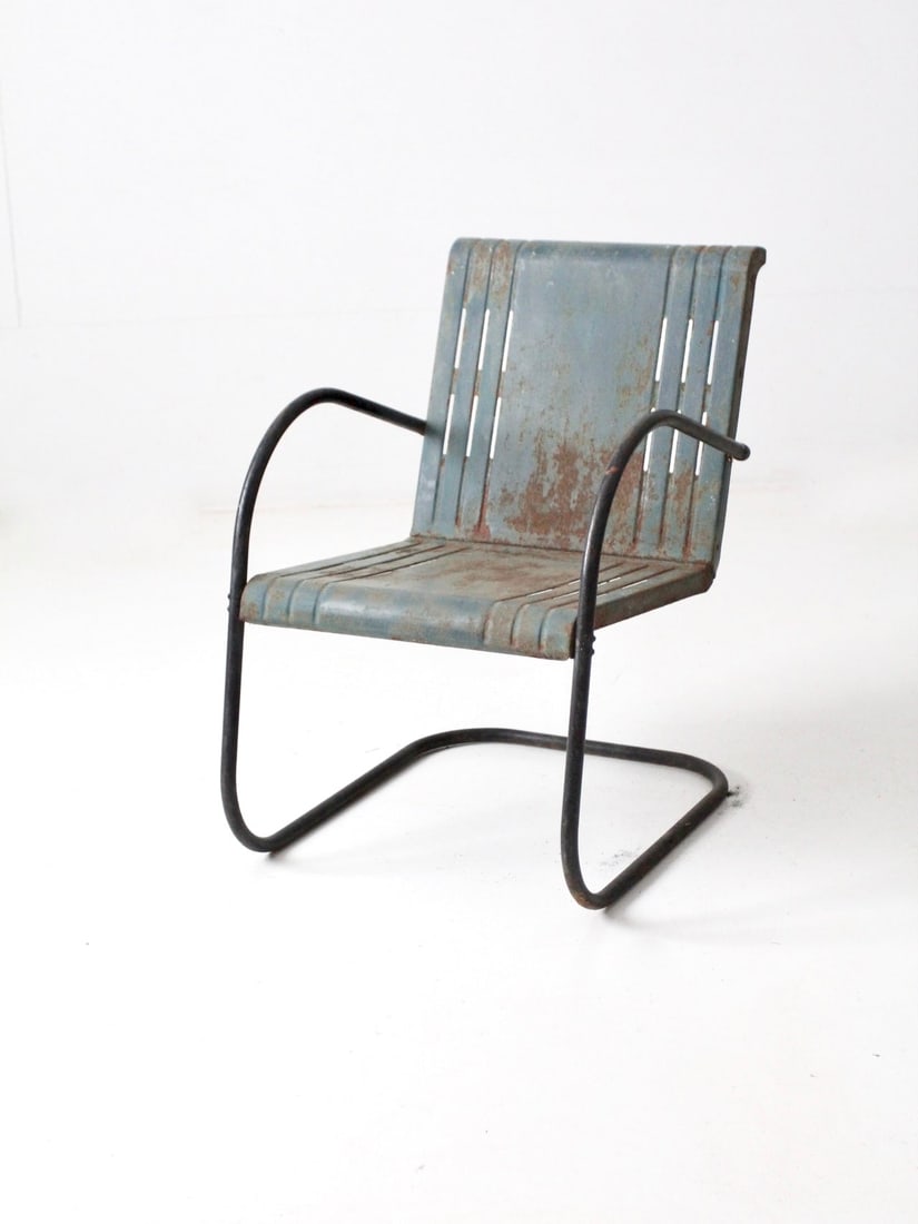 Vintage Mid-Century Blue Metal Bouncer Patio Chair: Vintage Mid-Century Blue Metal Bouncer Patio Chair This mid-century metal bouncer chair features a classic design with a blue bouncer frame and a unique window slit detailed seat. Constructed for dura