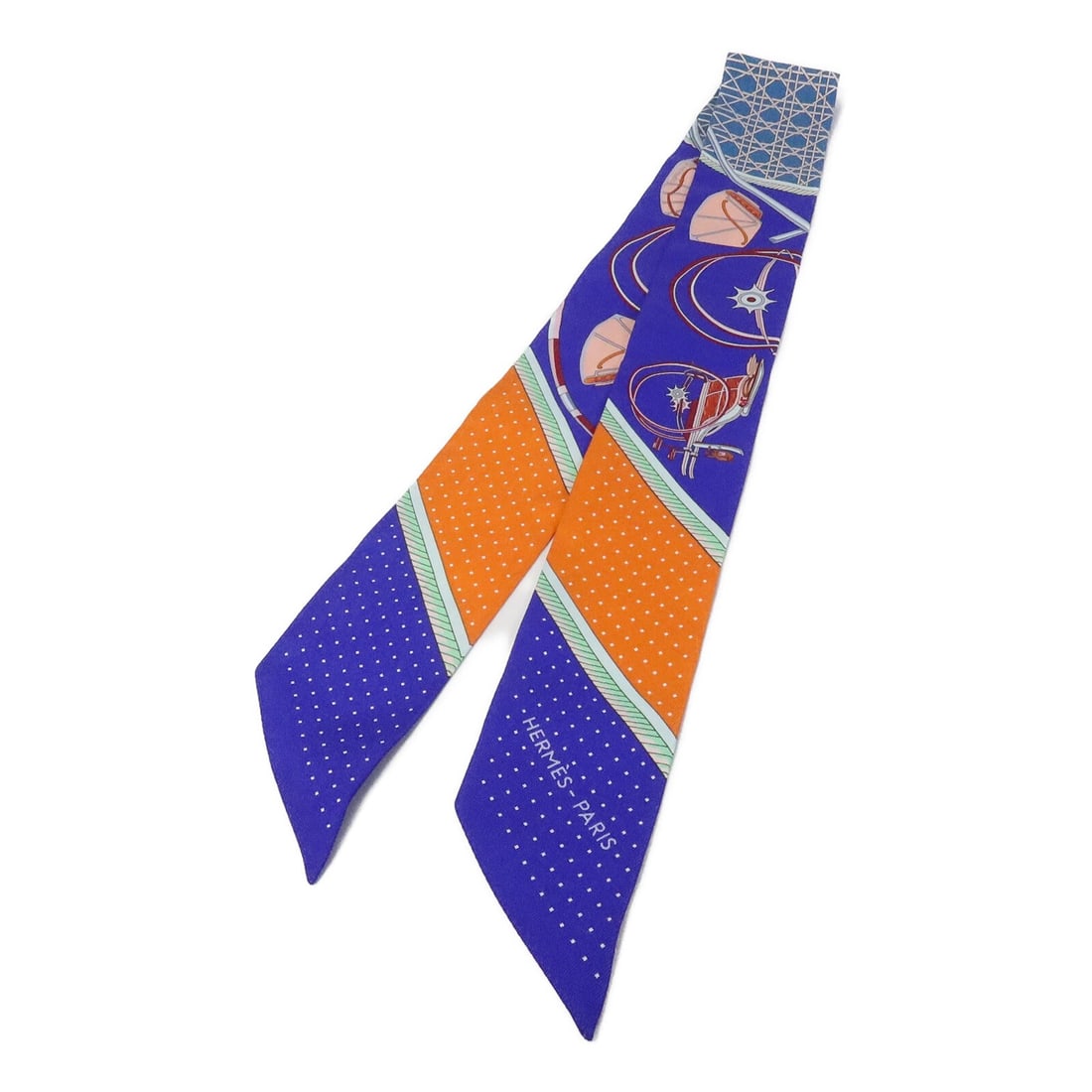 Hermes silk Twilly in blue and orange: Hermes silk Twilly in blue and orange This Hermes Twilly scarf is crafted from luxurious silk and features a vibrant blue and orange color palette. Designed for women, it offers a stylish accent to an