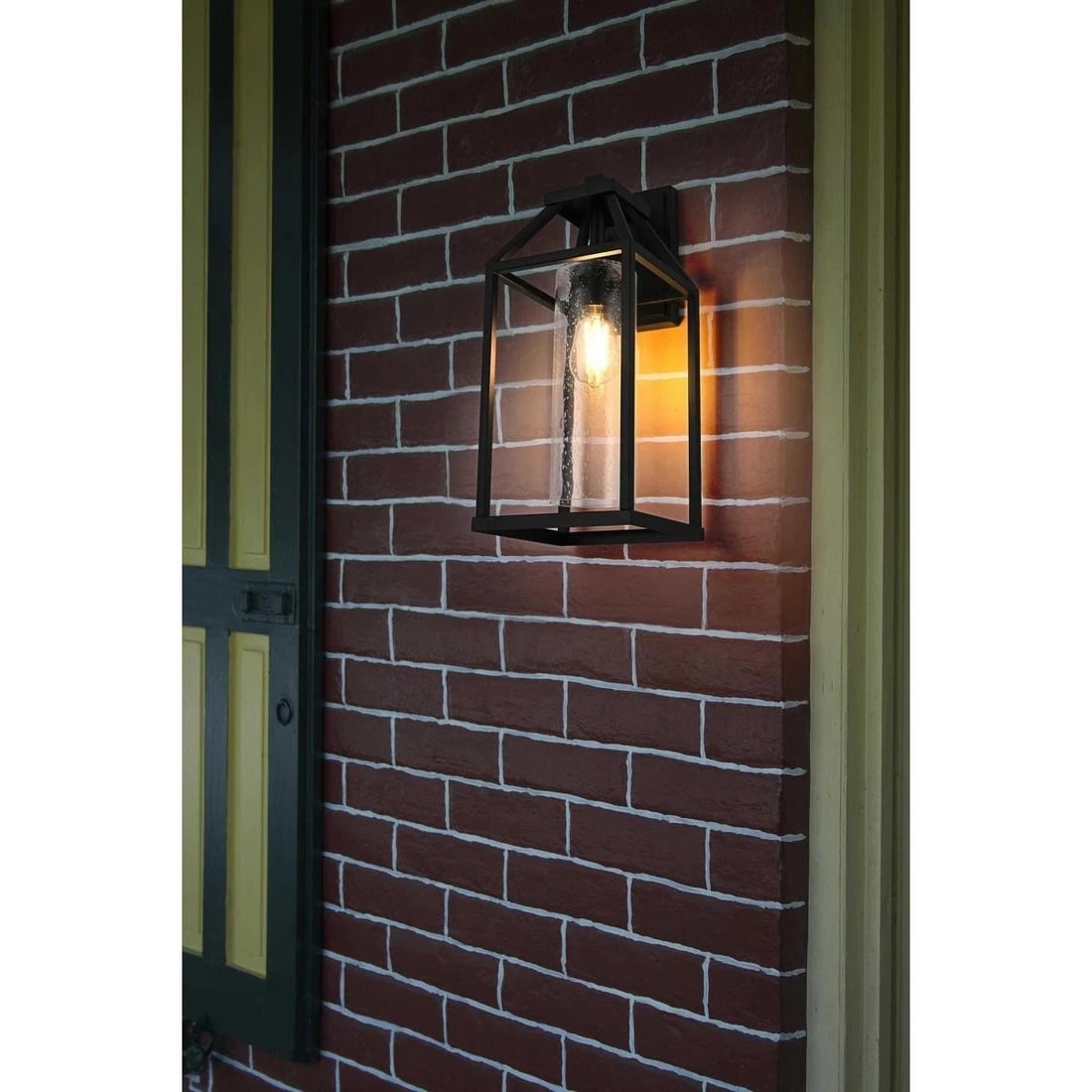 Zora Black Seedy Glass Outdoor Wall Light 18.74 Inch: Zora Black Seedy Glass Outdoor Wall Light 18.74 Inch This large outdoor wall sconce features a traditional design with a tapered rectangular frame and a pitched roof, reminiscent of classic gas lanter