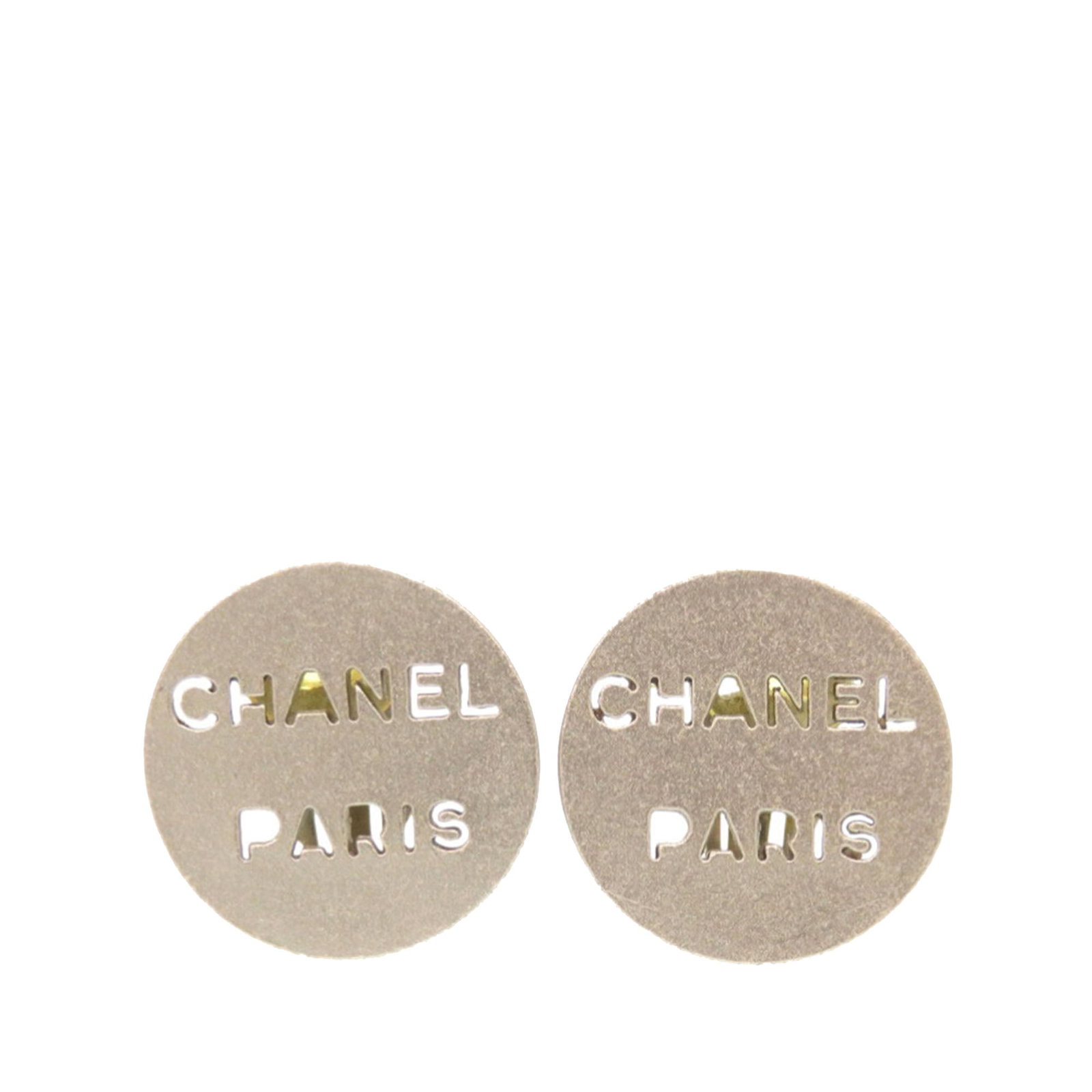 Chanel silver tone clip on round logo earrings: Chanel silver tone clip on round logo earrings These Chanel round clip-on earrings feature a silver-tone metal body with a distinctive cut-out logo design. Made in France, they are crafted in a costum