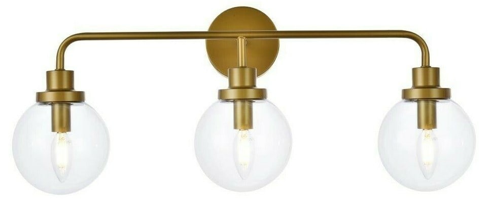 Hanson 3 Light Brass Wall Sconce with Clear Glass Shades: Hanson 3 Light Brass Wall Sconce with Clear Glass Shades This modern wall sconce features a brass-colored metal frame with three clear glass round shades, providing both upward and downward lighting.