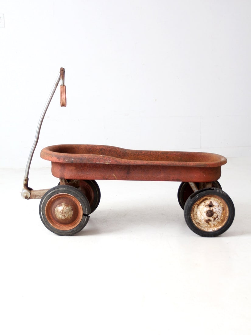 1930s Vintage Red Metal Pull Wagon Americana Decor: 1930s Vintage Red Metal Pull Wagon Americana Decor This vintage red metal pull wagon, dating back to the 1930s, is reminiscent of the early Murray Mercury models. Its classic silhouette and timeworn f