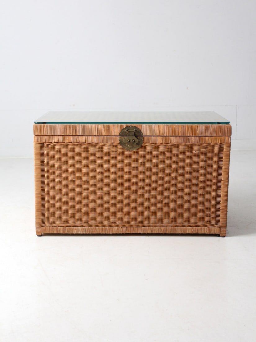 Vintage Rattan Trunk with Glass Top and Brass Hardware: Vintage Rattan Trunk with Glass Top and Brass Hardware Elevate your living space with this vintage rattan trunk featuring a stylish glass top. The trunk's woven rattan design offers a natural texture 