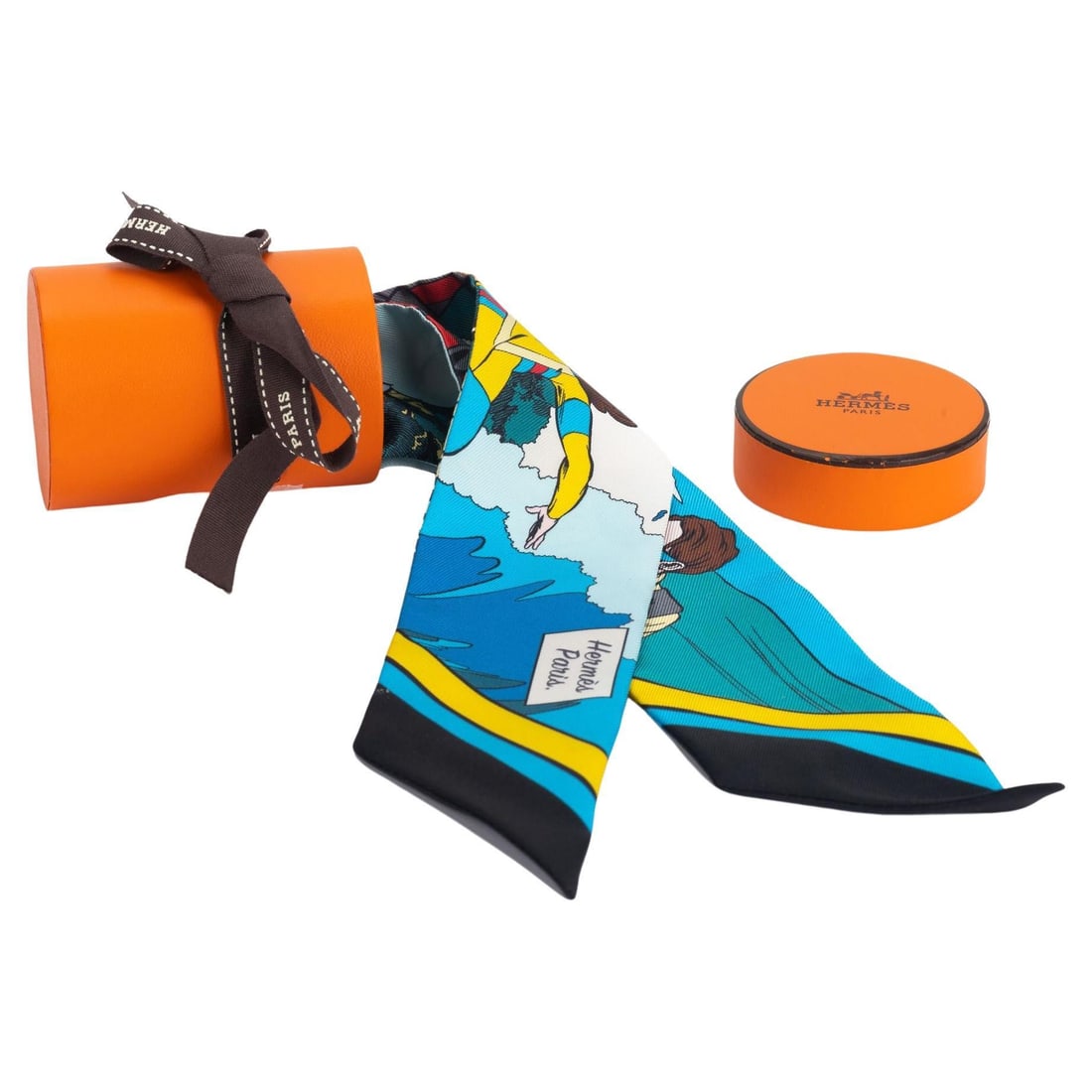 Hermes Comic Twilly Superwoman Blue Scarf 33.9 in France: Hermes Comic Twilly Superwoman Blue Scarf 33.9 in France Introducing the exquisite Hermes Comic Twilly, a stunning accessory that showcases a whimsical comic pattern featuring a superwoman in vibrant 