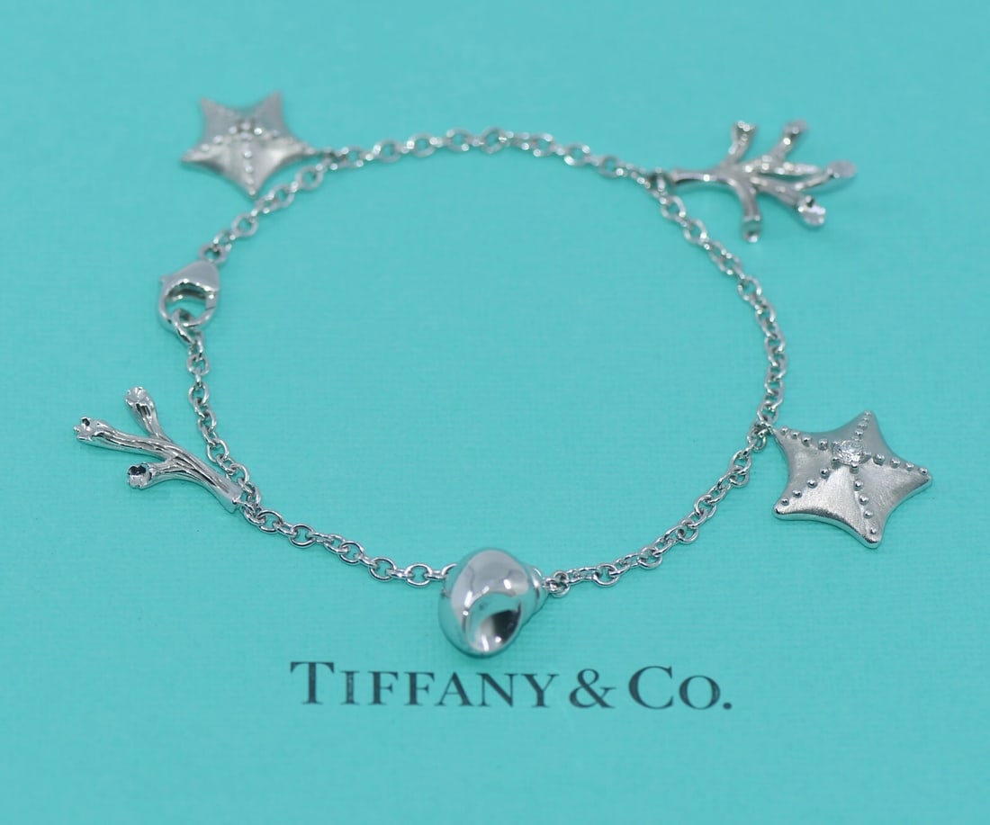 Tiffany & Co 5 Charm Diamond Bracelet 18K White Gold Authentic: Tiffany & Co 5 Charm Diamond Bracelet 18K White Gold Authentic This exquisite Tiffany & Co. bracelet showcases a stunning charm design featuring five diamonds, elegantly crafted from 18K white gold.