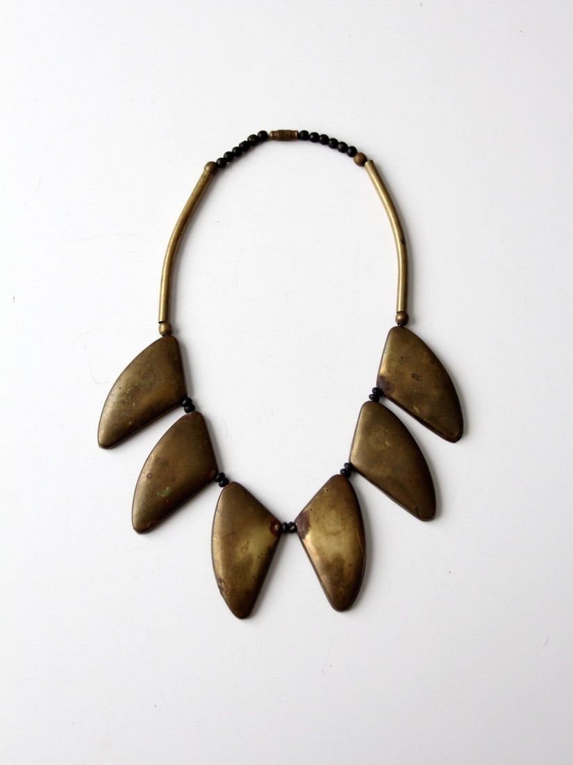 Vintage Brutalist Brass Collar Necklace with Beads and Patina: Vintage Brutalist Brass Collar Necklace with Beads and Patina This vintage Brutalist brass collar necklace showcases a stunning arrangement of sculptural brass shields that create a bold, collar-like 