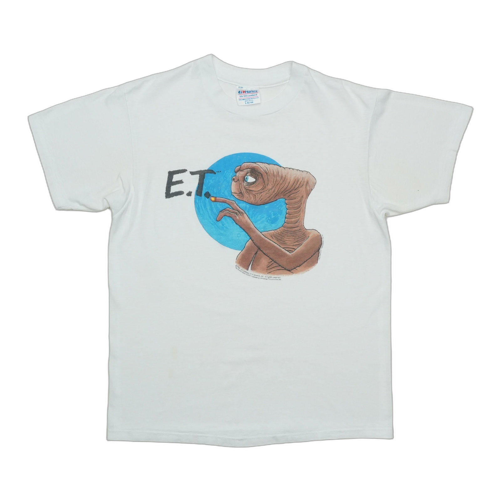 Vintage 1982 E.T. Front Graphic White Cotton Poly Shirt Large: Vintage 1982 E.T. Front Graphic White Cotton Poly Shirt Large This is an original vintage 1982 E.T. The Extra Terrestrial shirt featuring a front graphic design. The shirt is not a modern reproduction