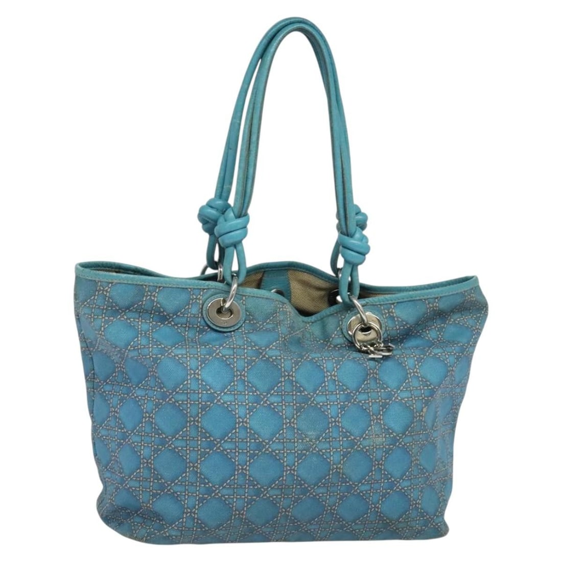 Blue Coated Canvas Tote Bag by Christian Dior with Silver Accents and Charm: Blue Coated Canvas Tote Bag by Christian Dior with Silver Accents and Charm This Christian Dior Cannage tote bag is crafted from blue and silver coated canvas and features a spacious design. The bag i
