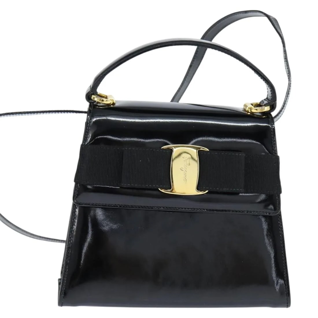 Black Patent Leather Vala Handbag by Salvatore Ferragamo: Black Patent Leather Vala Handbag by Salvatore Ferragamo This Salvatore Ferragamo Vala handbag for women is crafted from black patent leather. It features a compact design with dimensions of 19cm x 15
