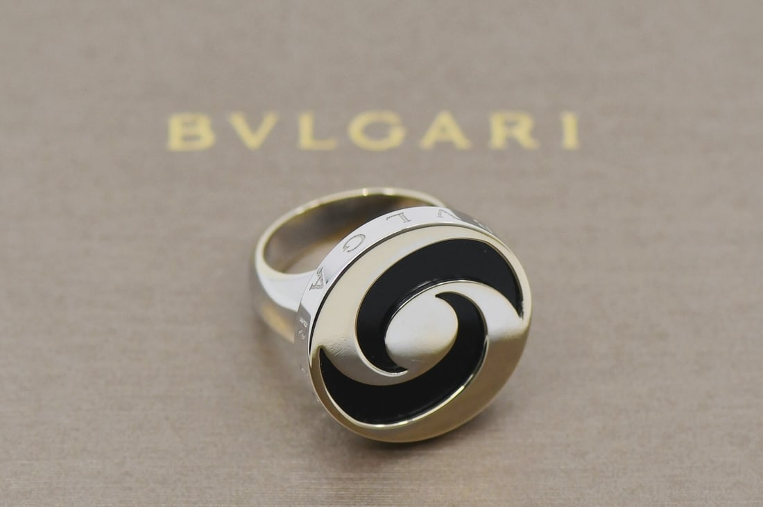 Bvlgari Onyx Spinning 18K White Gold Steel Ring Size 7 Authentic: Bvlgari Onyx Spinning 18K White Gold Steel Ring Size 7 Authentic This exquisite Bvlgari ring features a stunning combination of 18K white gold and stainless steel, showcasing the iconic Onyx spinning 