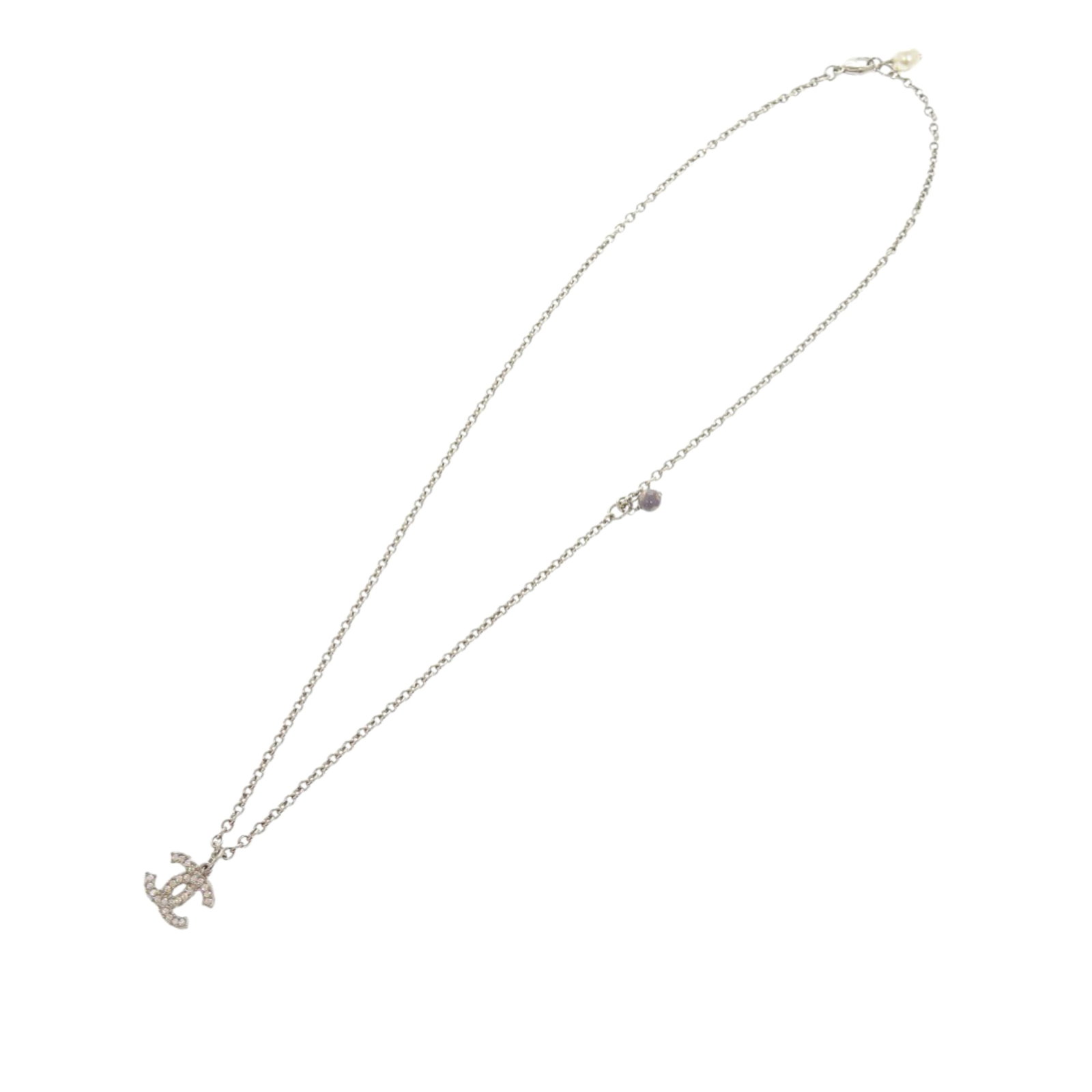 Chanel silver tone CC pendant necklace with faux pearls: Chanel silver tone CC pendant necklace with faux pearls This Chanel necklace showcases a silver-tone pendant embellished with rhinestones and faux pearls, suspended from a silver-tone chain with a lob
