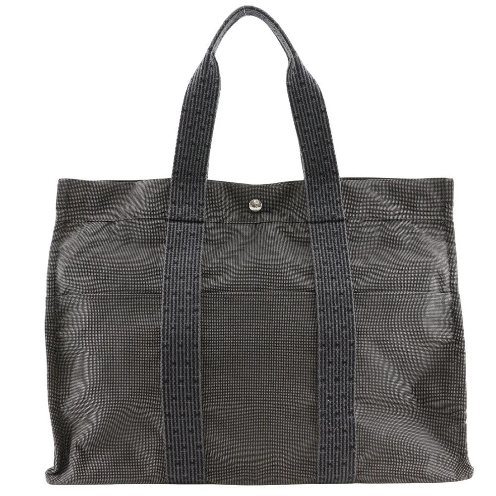 Hermes Fourre-tout Herline Gray Canvas Tote Bag 47cm by 34cm by 15cm: Hermes Fourre-tout Herline Gray Canvas Tote Bag 47cm by 34cm by 15cm The Hermes Fourre-tout Herline is a unisex tote bag crafted from durable gray canvas. It features a spacious design suitable for ev