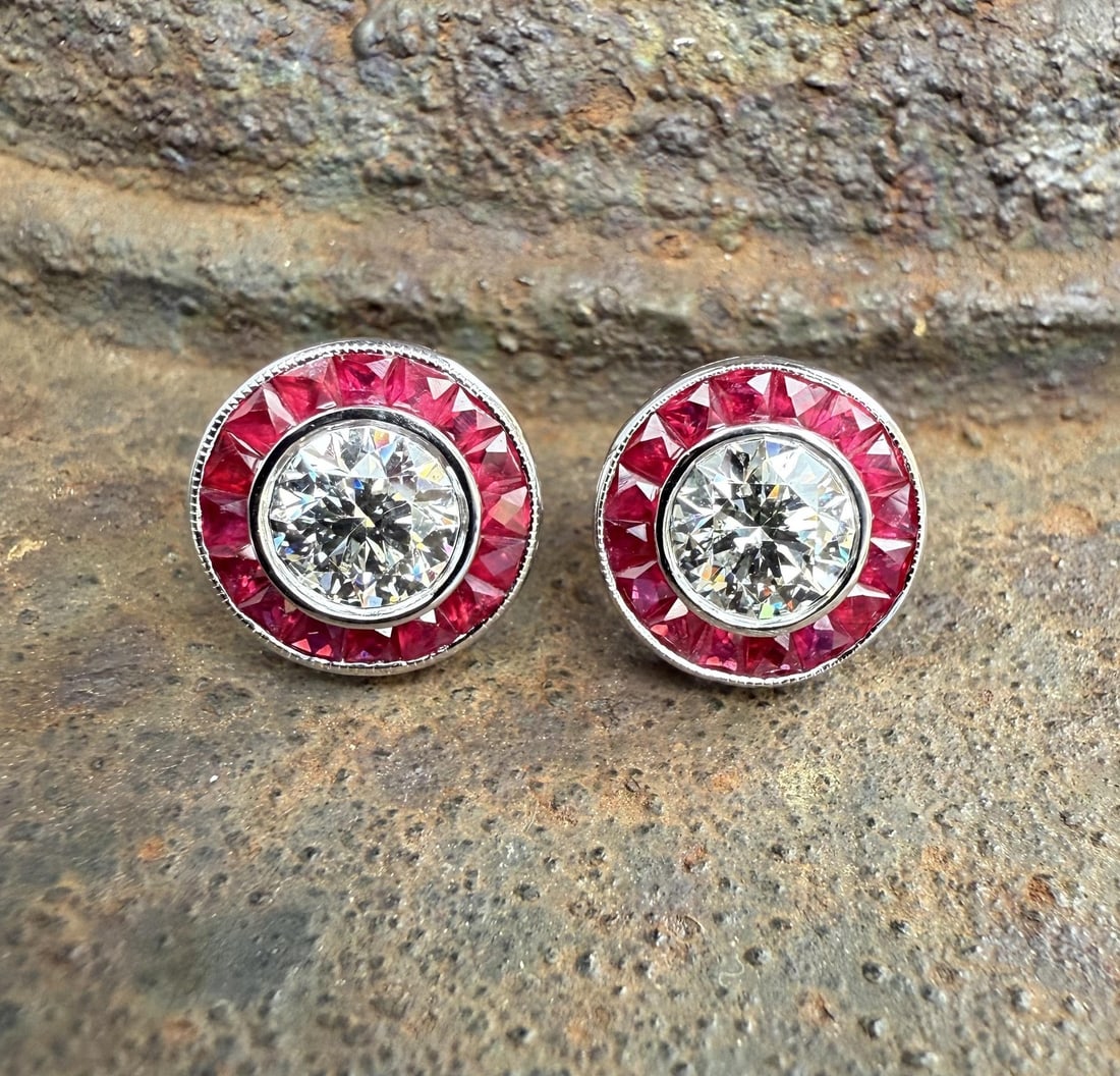 GIA Certified Diamond and Ruby Halo Earrings in 18k White Gold: GIA Certified Diamond and Ruby Halo Earrings in 18k White Gold These un-used stud earrings feature two natural, round brilliant cut diamonds with a total weight of 1.82 carats, each independently GIA 