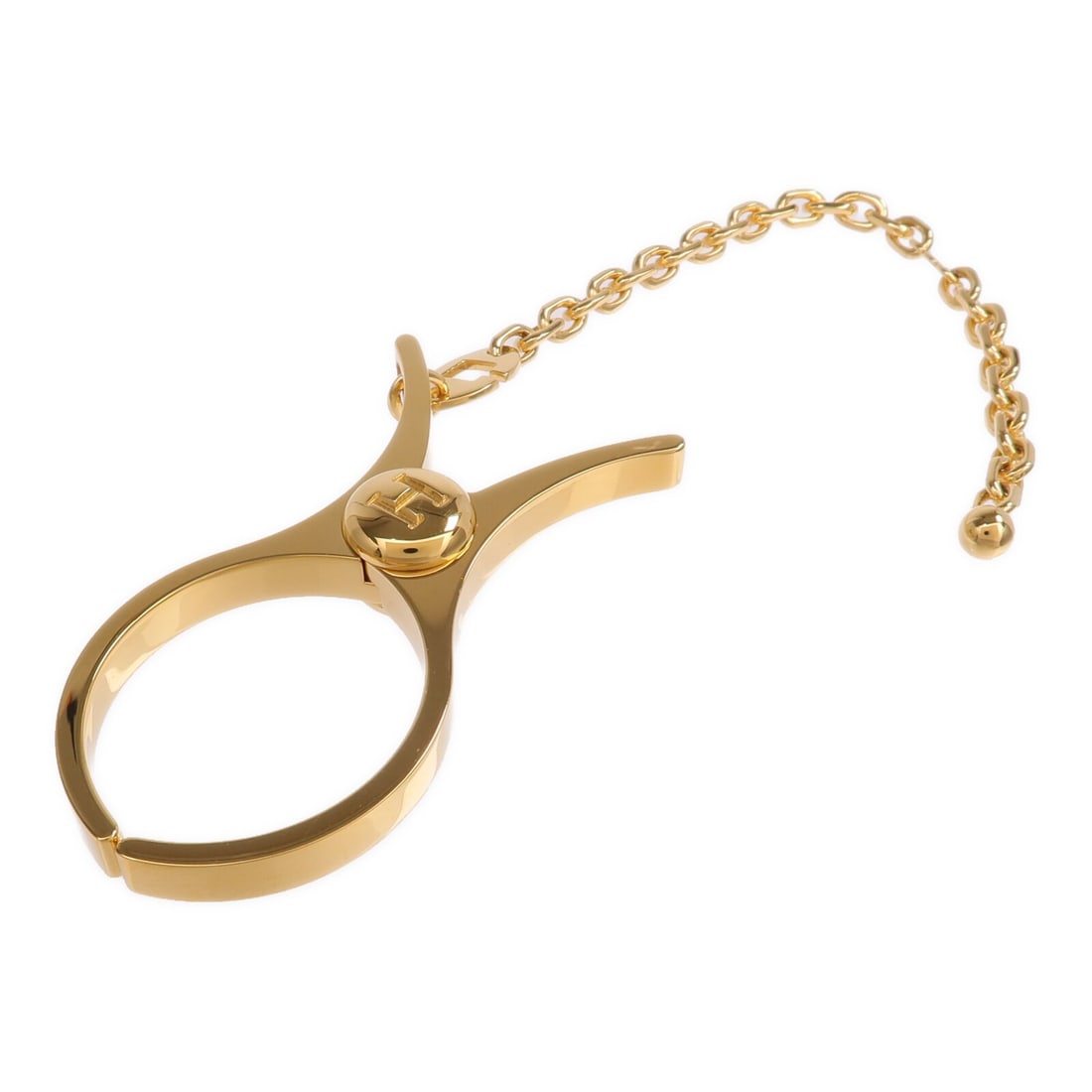 Filou Gold Tone Metal Glove Clip by Hermes France: Filou Gold Tone Metal Glove Clip by Hermes France Hermes Filou glove clip crafted from gold-tone metal. This stylish accessory is designed for securely holding gloves and features a sleek gold color. 