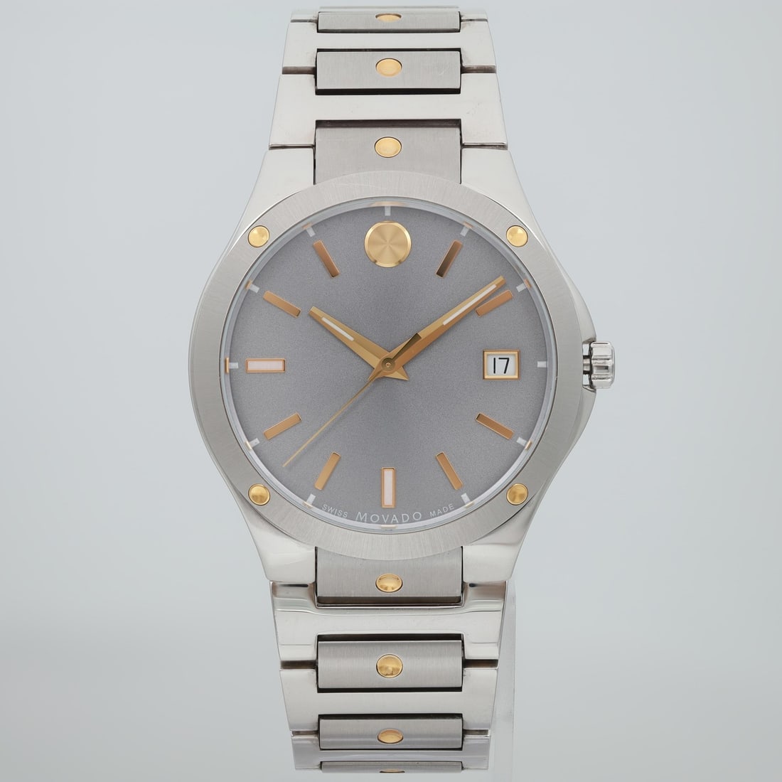 Movado SE mens 41mm quartz wristwatch with gray dial steel bracelet: Movado SE mens 41mm quartz wristwatch with gray dial steel bracelet Pre-owned Movado SE men's wristwatch with a two-tone stainless steel bracelet and grey sunburst analog dial. This quartz watch featu