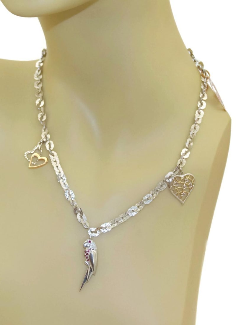 18k Tricolor Gold Charm Necklace with Hearts and Bird: 18k Tricolor Gold Charm Necklace with Hearts and Bird This elegant necklace is crafted from 18k white, rose, and yellow gold, featuring a combination of polished and textured finishes. The design incl