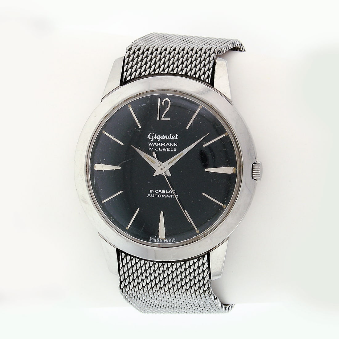 Vintage Wakmann Gigandet 35mm Automatic Steel Mesh Wrist Watch 17 Jewels: Vintage Wakmann Gigandet 35mm Automatic Steel Mesh Wrist Watch 17 Jewels Discover a classic timepiece with this Vintage Gigandet Wakmann Steel Mesh Black 35mm Automatic Wrist Watch. Crafted in Switzer
