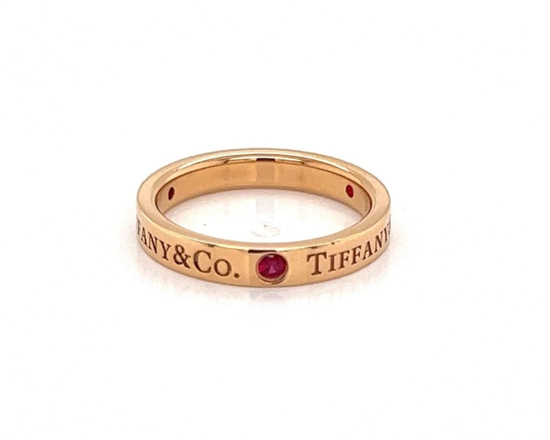 Tiffany & Co. 18k Rose Gold Ruby Band Ring US Size 4.5: Tiffany & Co. 18k Rose Gold Ruby Band Ring US Size 4.5 A fine Tiffany & Co. ruby band ring crafted in 18k rose gold. The sleek flat band design features three ruby accents and a minimalist profile. It