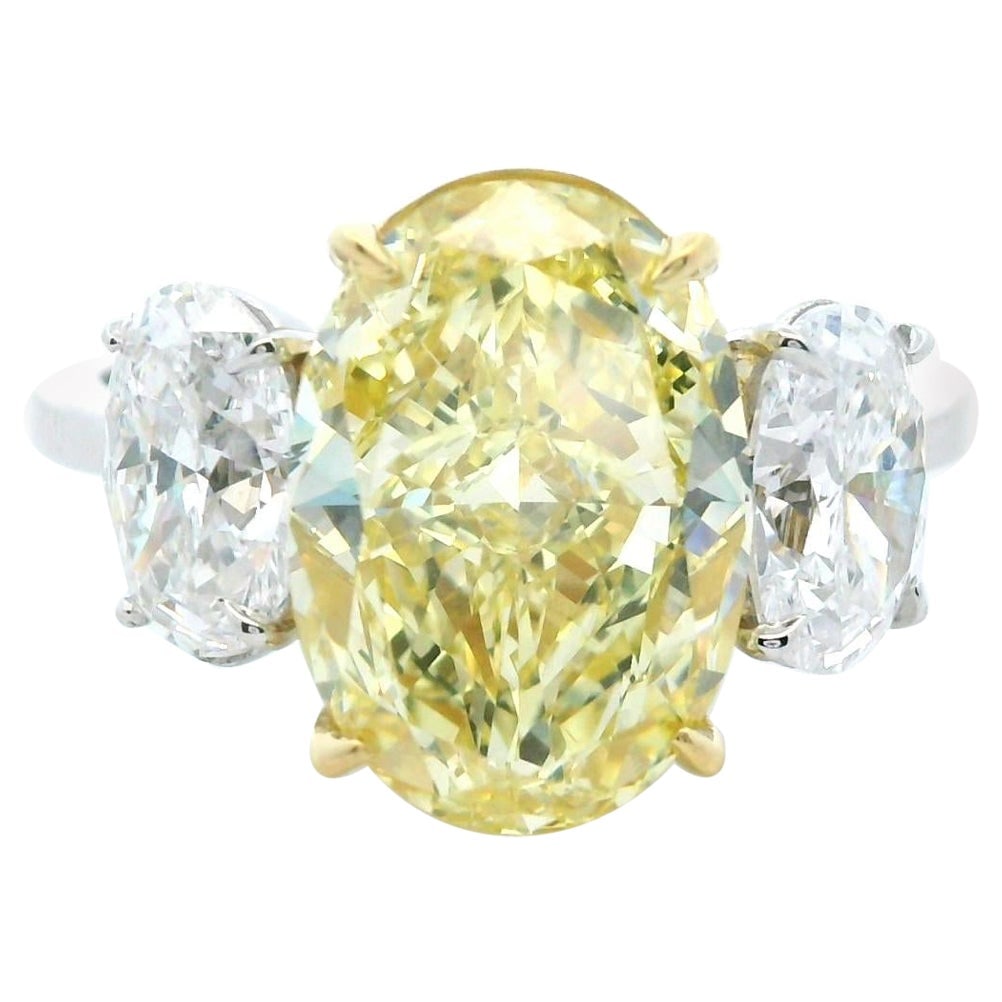 4.44ct GIA Fancy Intense Yellow Diamond Ring 18k: 4.44ct GIA Fancy Intense Yellow Diamond Ring 18k This exquisite ring features a stunning GIA certified 4.44 carat oval fancy intense yellow canary diamond, complemented by two oval brilliant diamonds 