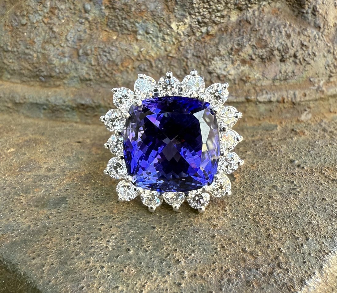 GIA Certified Cushion Tanzanite and Diamond Halo Ring in 18k White Gold: GIA Certified Cushion Tanzanite and Diamond Halo Ring in 18k White Gold This cocktail ring features a large, natural cushion-cut tanzanite certified by GIA, showcasing a vibrant blue-violet color. The