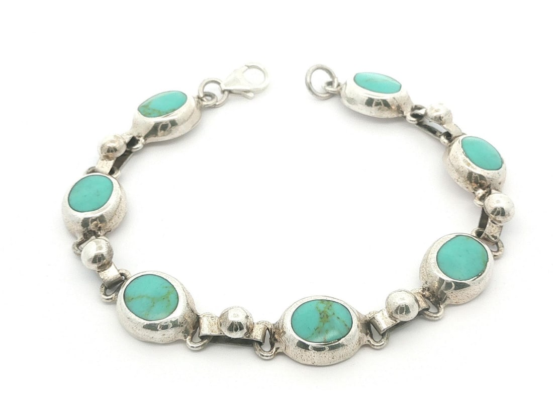 Sterling Silver Turquoise Line Link Bracelet 7 Stone Oval Cabochons: Sterling Silver Turquoise Line Link Bracelet 7 Stone Oval Cabochons This vintage bracelet features a line link design crafted from solid sterling silver and showcases seven natural turquoise stones. E