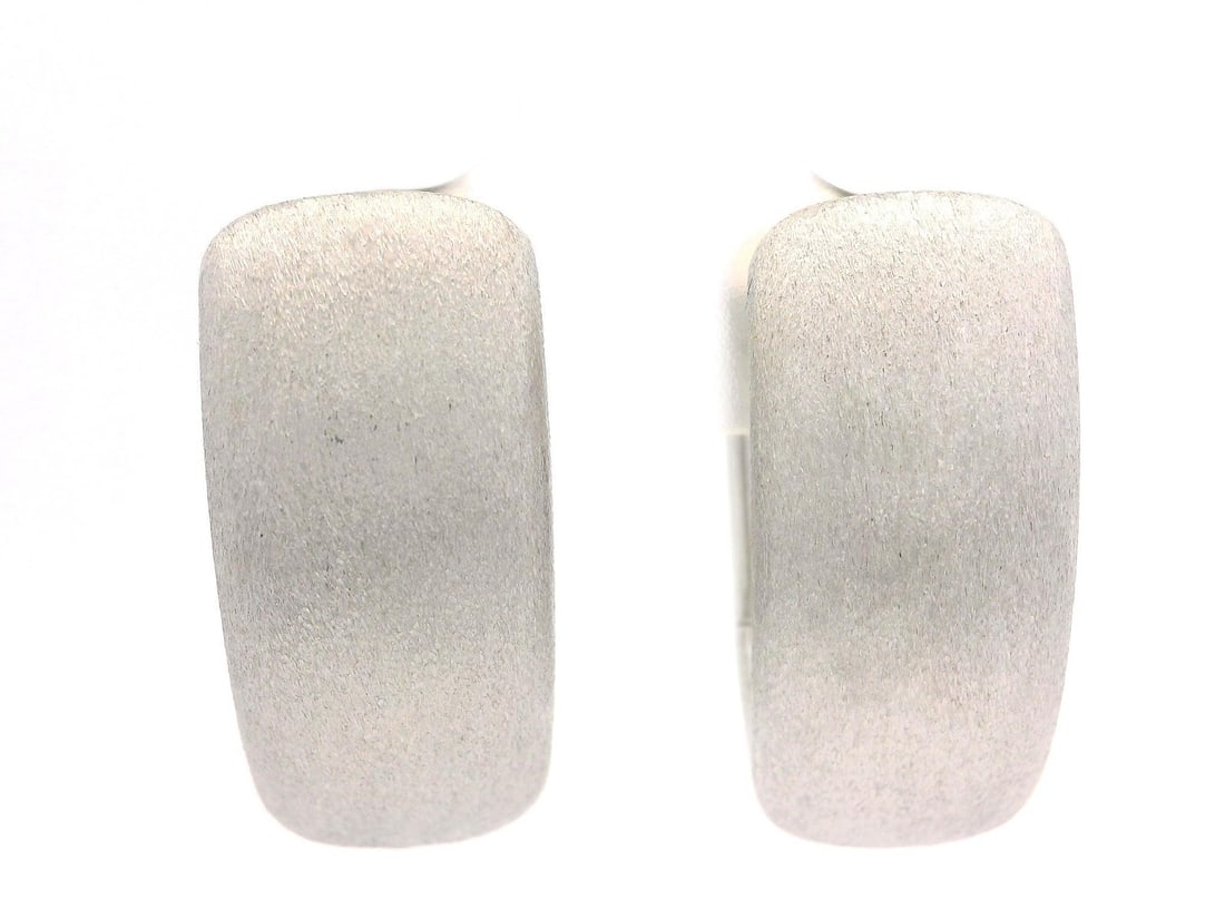 18k White Gold Brushed Huggie Snap Earrings: 18k White Gold Brushed Huggie Snap Earrings These elegant huggie snap earrings are crafted from solid 18k white gold, featuring a brushed stone finish that adds a sophisticated touch to any outfit. De
