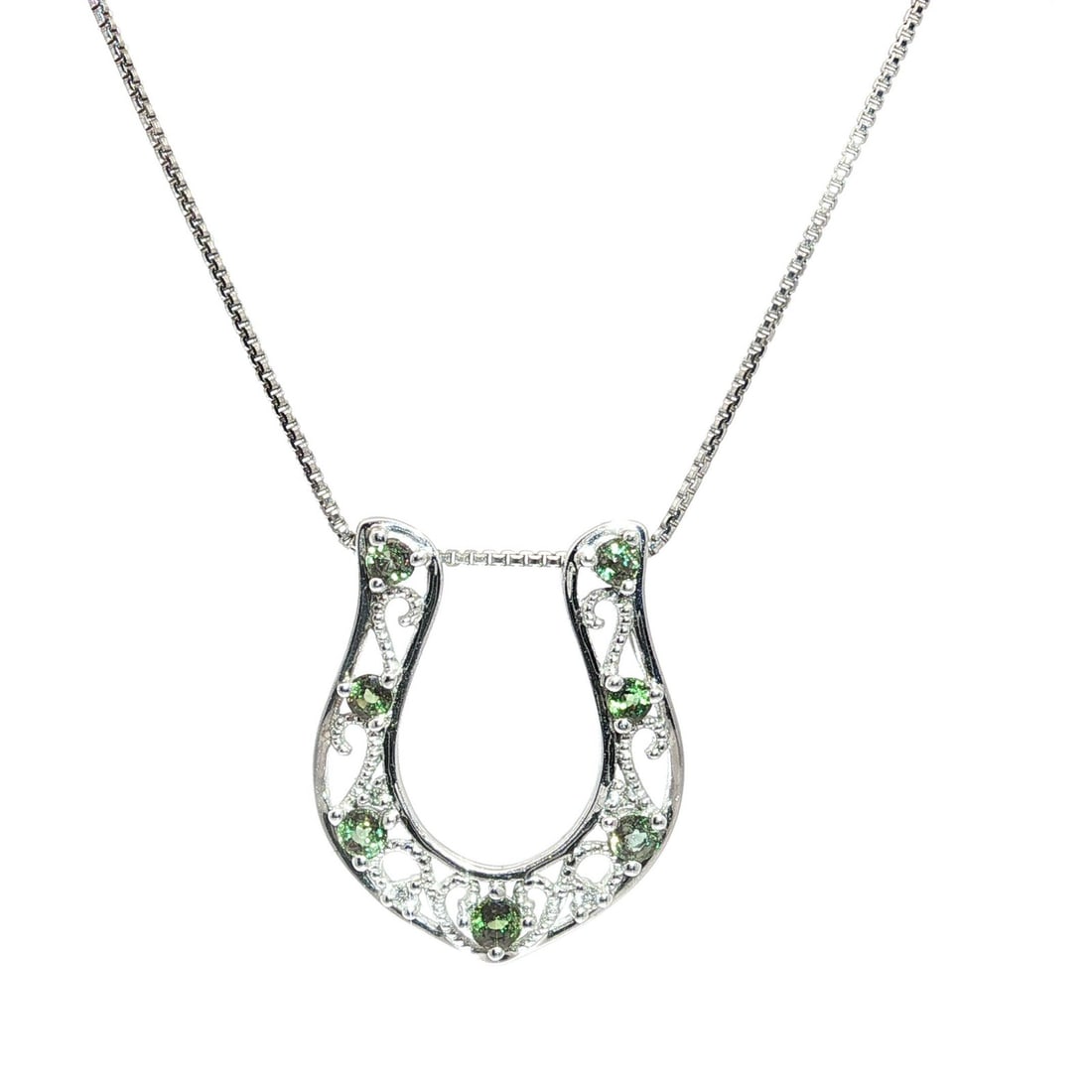 Natural Alexandrite and Diamond Horseshoe Necklace in 18k White Gold: Natural Alexandrite and Diamond Horseshoe Necklace in 18k White Gold This elegant necklace features a horseshoe-shaped pendant crafted in solid 18k white gold. The pendant is adorned with seven natura