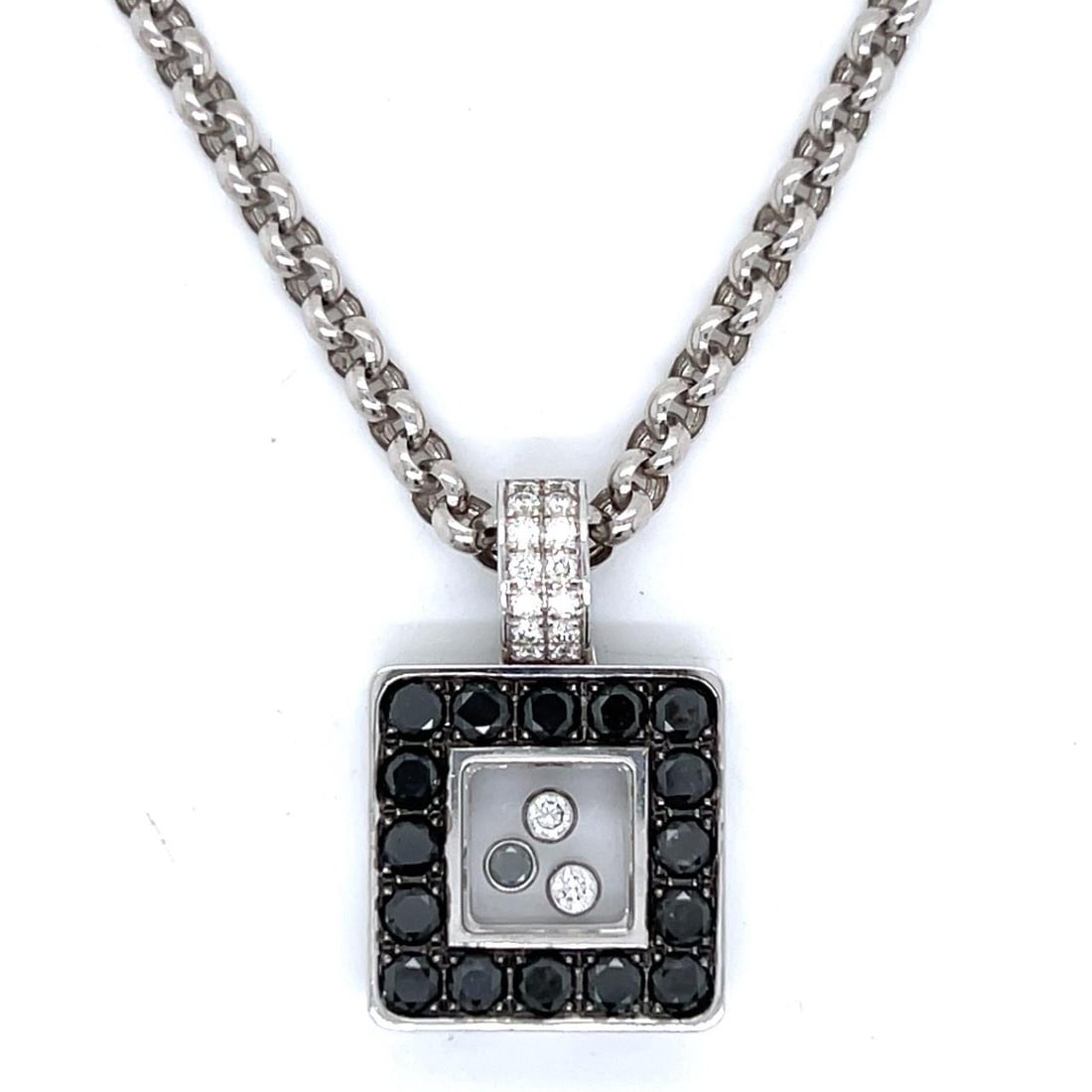 Chopard 18K White Gold Black Diamond Pendant Necklace with Certificate: Chopard 18K White Gold Black Diamond Pendant Necklace with Certificate This exquisite Chopard pendant and necklace set is crafted in 18K white gold and features a stunning arrangement of diamonds. The