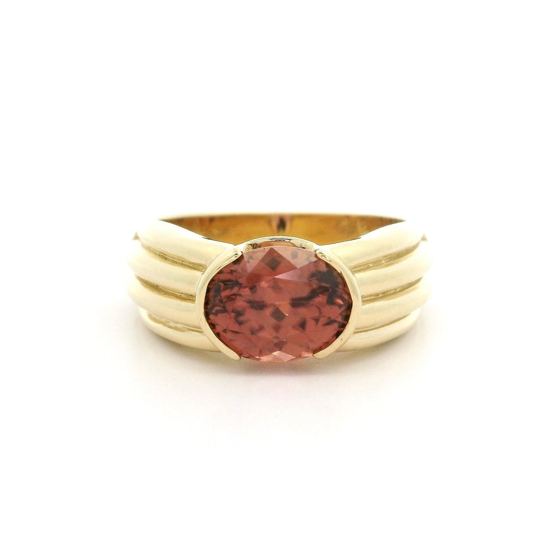 14k Yellow Gold 5.21ct Oval Orangy Pink Imperial Zircon Ring: 14k Yellow Gold 5.21ct Oval Orangy Pink Imperial Zircon Ring This stunning ring features a solid 14k yellow gold band showcasing a captivating 5.21ct oval orangy pink imperial zircon. The natural gems