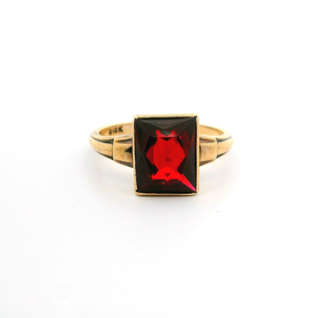 Antique 10k Yellow Gold Bezel Set Synthetic Ruby Solitaire Ring: Antique 10k Yellow Gold Bezel Set Synthetic Ruby Solitaire Ring This exquisite antique ring features a stunning rectangular synthetic ruby, elegantly bezel set in solid 10k yellow gold. The rich, deep