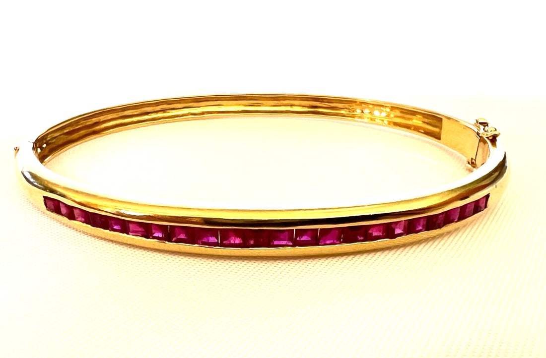 French 18K Yellow Gold Ruby Wrap Bracelet with Flower Detail: French 18K Yellow Gold Ruby Wrap Bracelet with Flower Detail This exquisite French bracelet is crafted from 18K yellow gold and features fine Berme rubies, totaling approximately 2.50 ct. The wrap sty