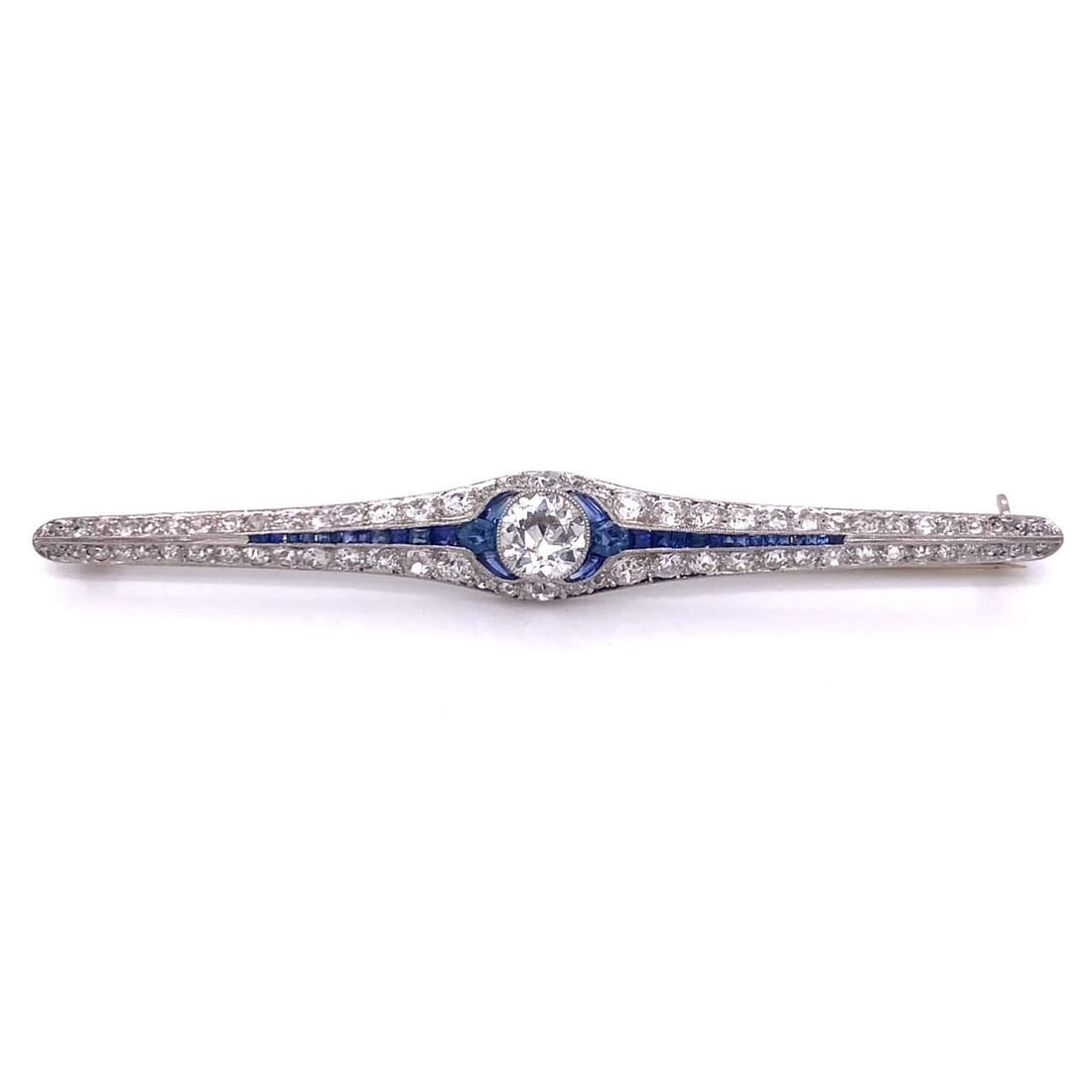 Art Deco Platinum Pin 5.55 Ct Diamond and Sapphire: Art Deco Platinum Pin 5.55 Ct Diamond and Sapphire This exquisite Art Deco pin features a stunning European cut diamond at its center, weighing approximately 1.05 Ct, surrounded by 70 additional diamo
