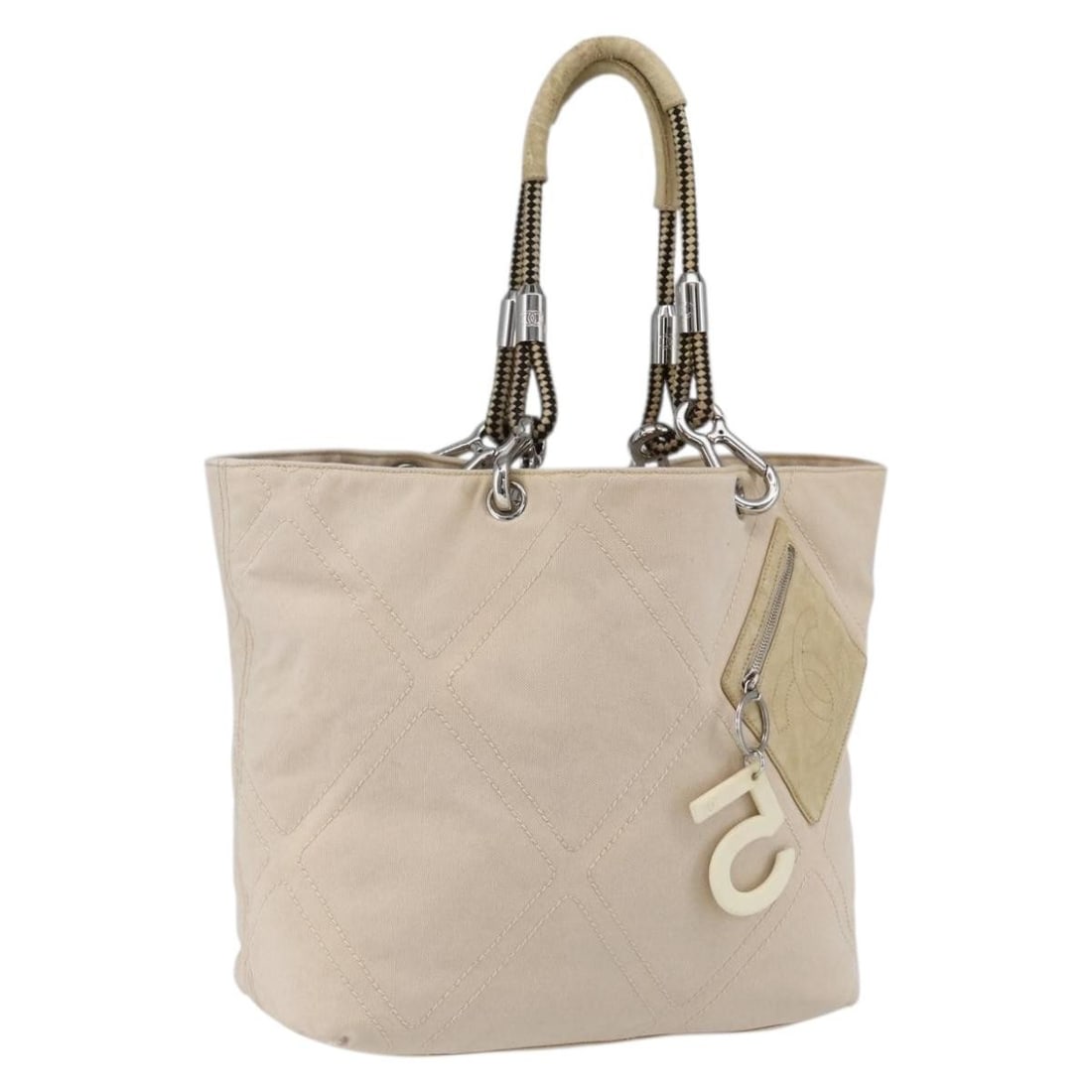 CHANEL CC Canvas Tote Handbag Beige Silver Italy: CHANEL CC Canvas Tote Handbag Beige Silver Italy Beige and silver CHANEL tote bag crafted from canvas, made in Italy. This pre-owned bag is offered in heavily used condition with visible wear througho