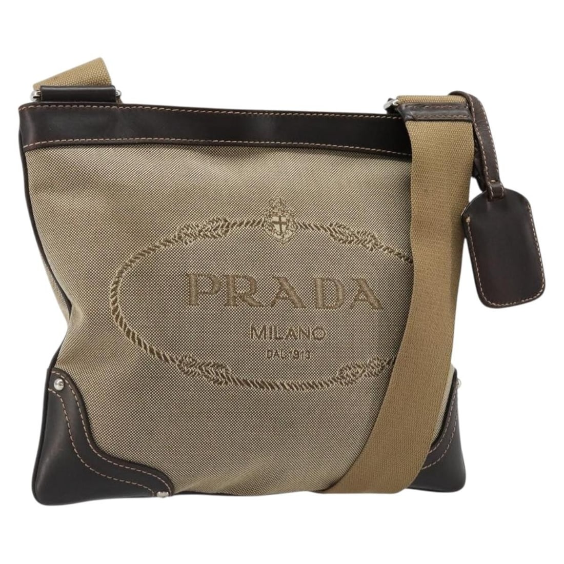 PRADA Canvas Shoulder Bag Beige Silver with Name Tag Made in Italy: PRADA Canvas Shoulder Bag Beige Silver with Name Tag Made in Italy PRADA shoulder bag in beige and silver canvas, made in Italy. It comes with a name tag accessory and features a shoulder strap with a