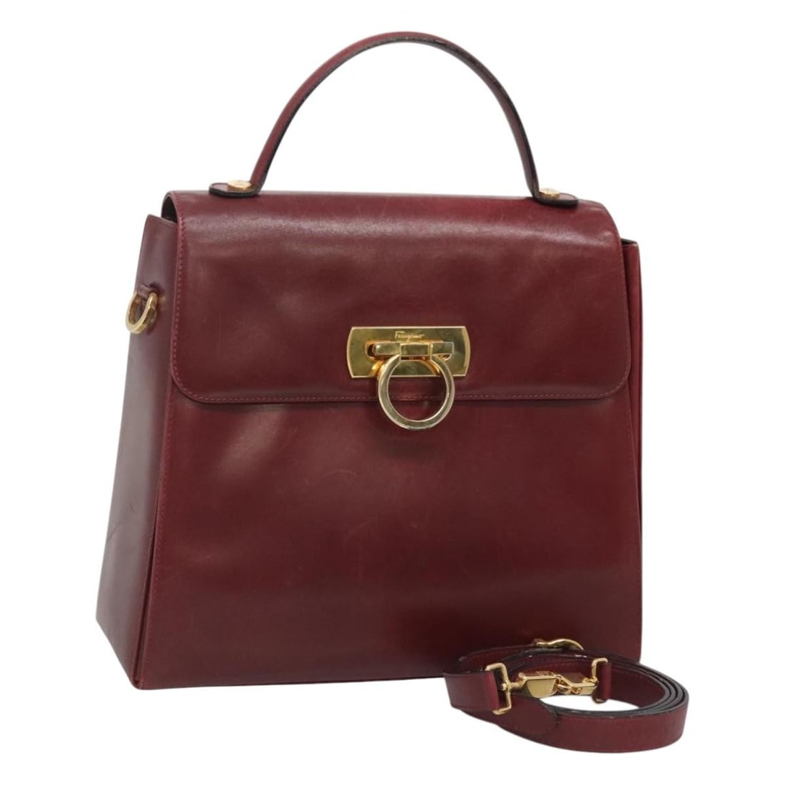 Salvatore Ferragamo Leather 2way Bordeaux Gold Hand Bag with Strap: Salvatore Ferragamo Leather 2way Bordeaux Gold Hand Bag with Strap This Salvatore Ferragamo handbag is crafted from leather in a Bordeaux and gold color combination. Designed for versatile use, it fea
