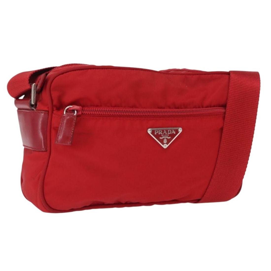 Red Nylon PRADA Shoulder Bag with Silver Accents Made in Italy: Red Nylon PRADA Shoulder Bag with Silver Accents Made in Italy This PRADA shoulder bag features a red nylon exterior with silver-tone accents. Designed with practicality in mind, it offers an adjustab