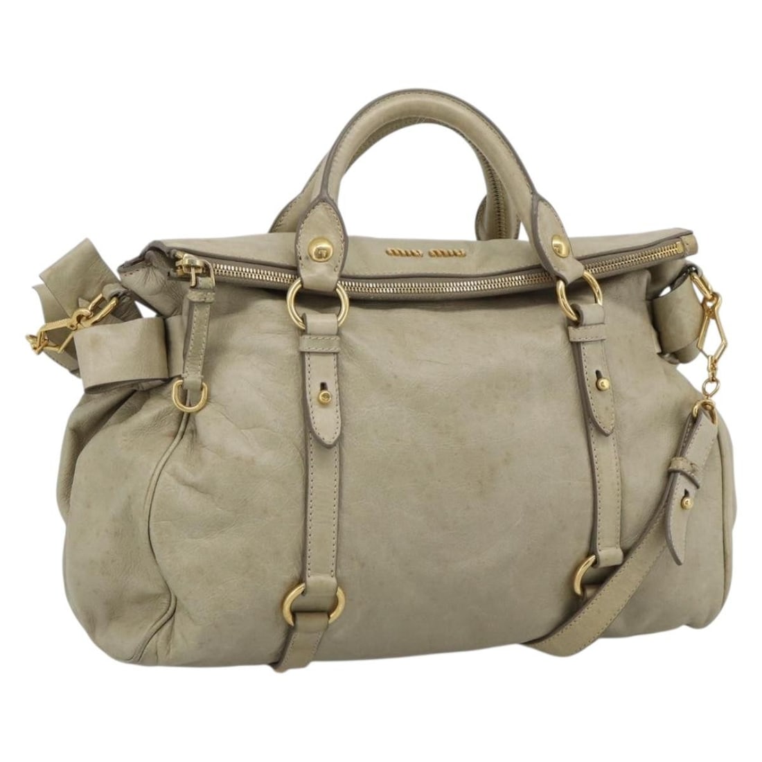 Miu Miu Beige Leather 2way Handbag with Shoulder Strap: Miu Miu Beige Leather 2way Handbag with Shoulder Strap A Miu Miu leather 2-way handbag in beige and gold. It includes a shoulder strap and was made in Italy. The bag shows heavy use with visible wear,