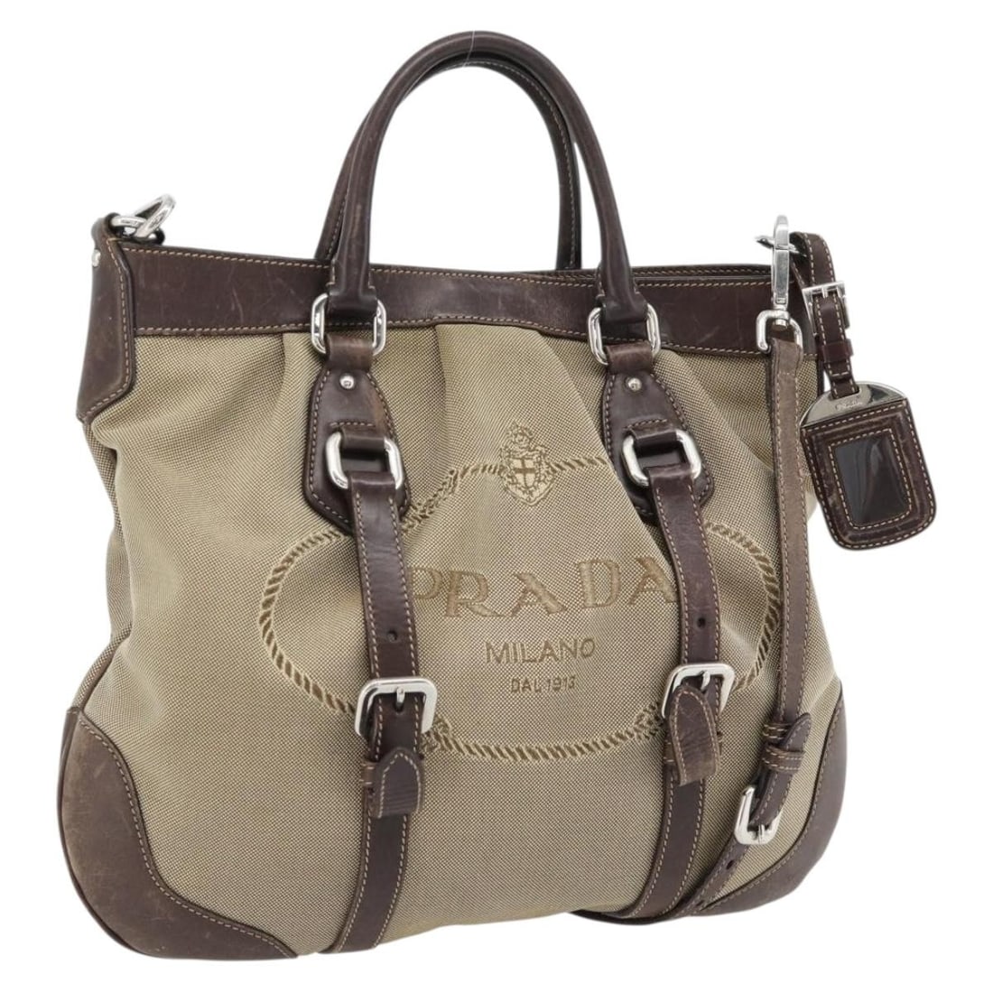 PRADA Beige Canvas 2way Handbag with Shoulder Strap and Name Tag: PRADA Beige Canvas 2way Handbag with Shoulder Strap and Name Tag Prada 2-way handbag in beige canvas with silver-tone accents, designed for women and made in Italy. This piece includes a name tag and 
