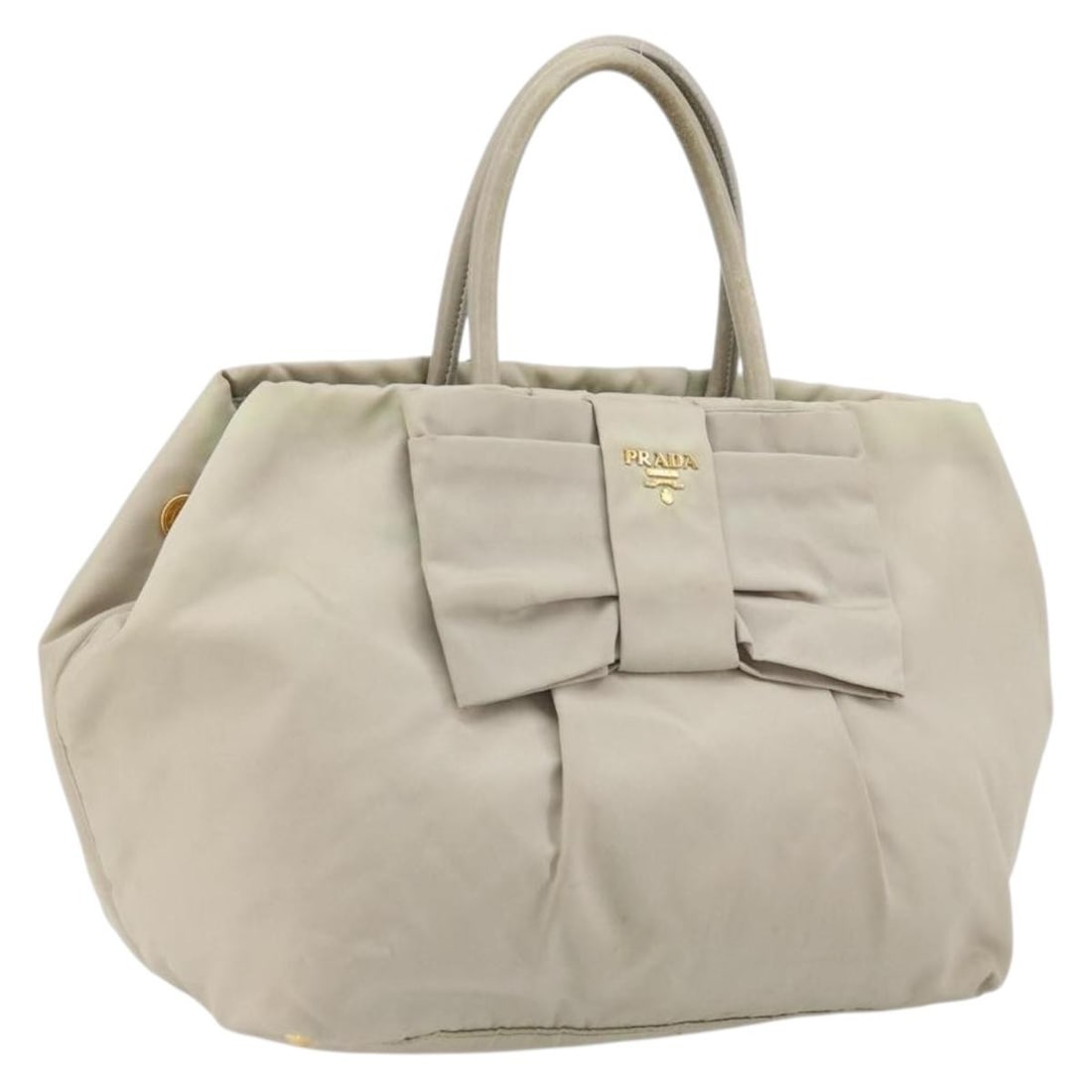 Prada Beige Gold Nylon Handbag Italy Ribbon Accent: Prada Beige Gold Nylon Handbag Italy Ribbon Accent This PRADA Ribbon handbag features a beige and gold nylon exterior with gold-tone accents. Designed for women, the bag is made in Italy and offers a 