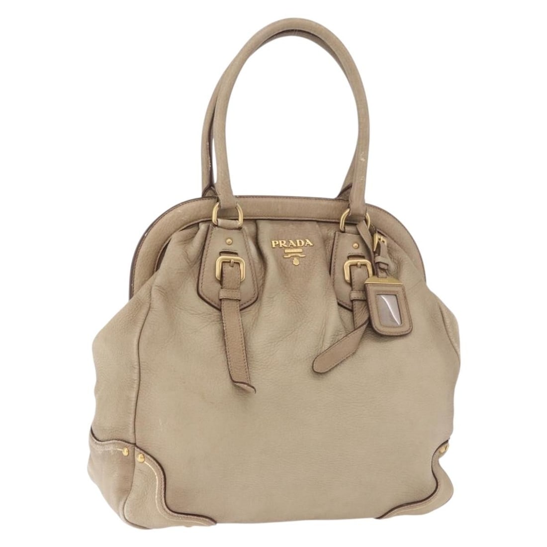 PRADA Beige Gold Leather Hand Bag with Name Tag: PRADA Beige Gold Leather Hand Bag with Name Tag This PRADA hand bag is made of leather in a beige and gold color combination. It is a women's style handbag made in Italy and comes with a name tag acce