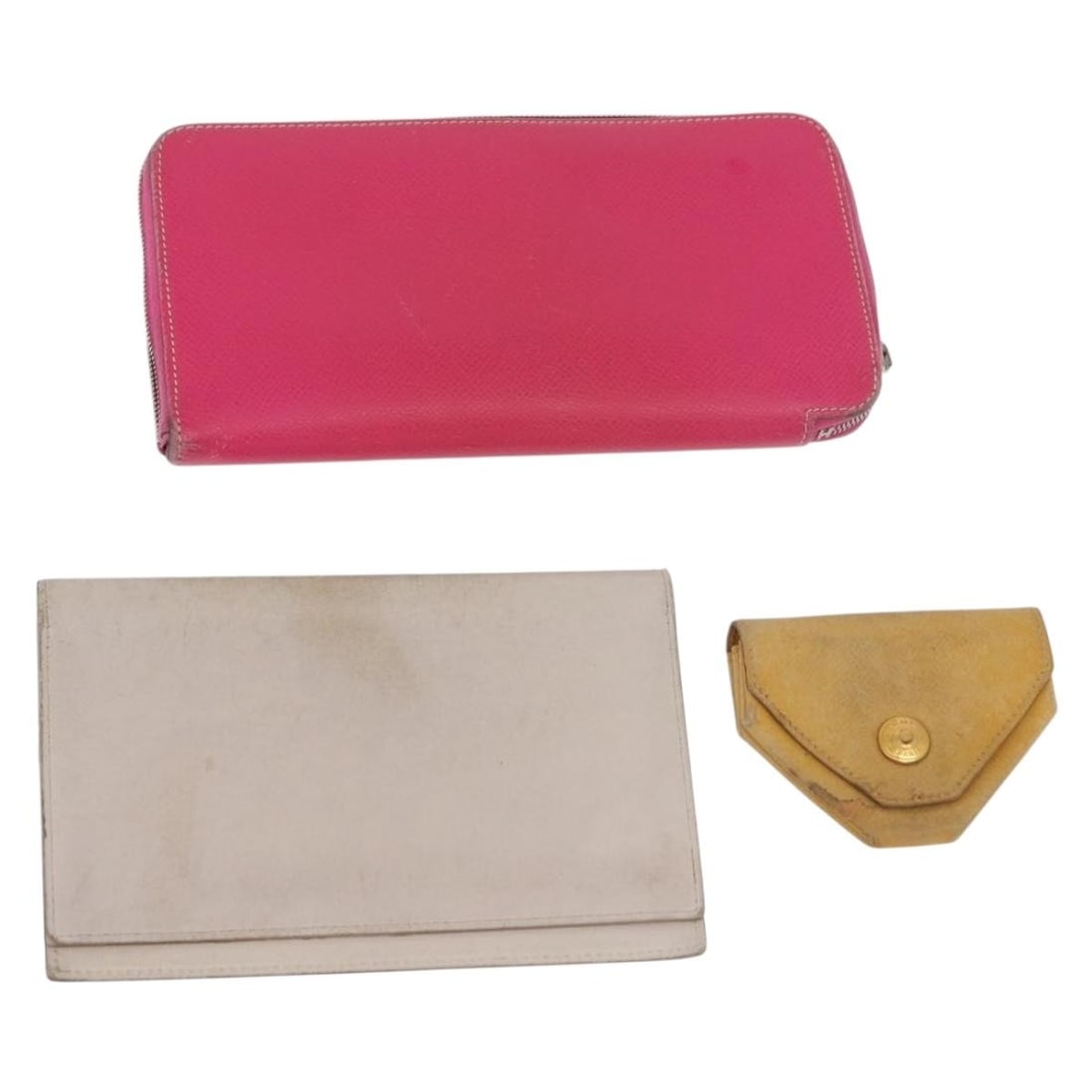 Hermes leather wallet set of 3 in pink red beige: Hermes leather wallet set of 3 in pink red beige Leather wallet set in pink, red, and beige, made in France. The item is offered as a special set sale and is in heavily used condition, with visible we