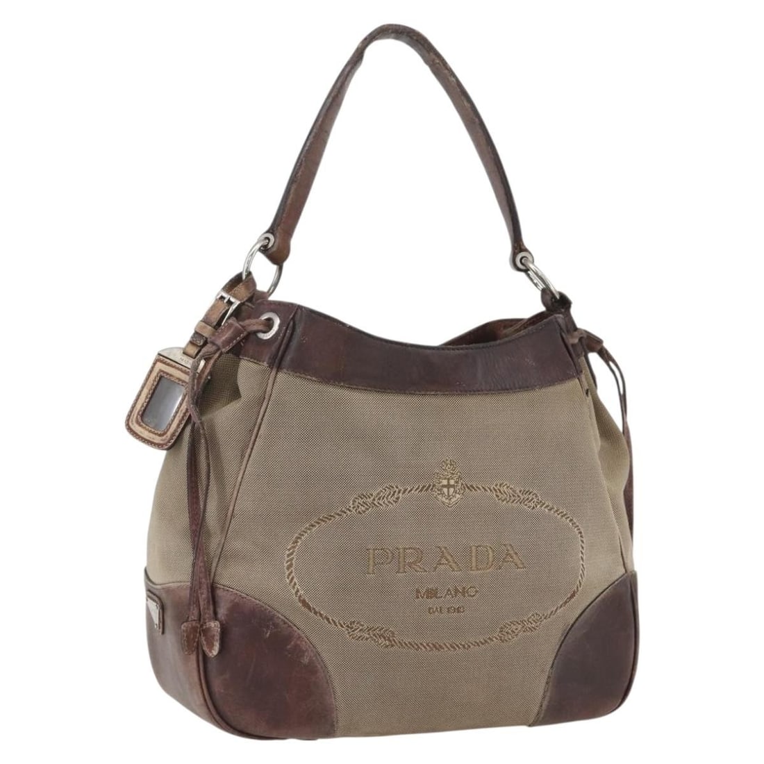 Prada Beige Canvas Tote with Silver Accents Made in Italy: Prada Beige Canvas Tote with Silver Accents Made in Italy This is a PRADA tote bag crafted from beige and silver canvas. Made in Italy, the bag features a spacious interior and dual top handles. The c