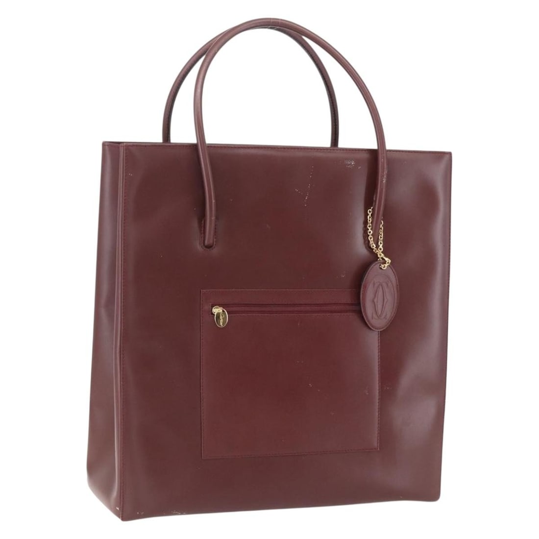 CARTIER Bordeaux Leather Tote Bag with Gold Accents: CARTIER Bordeaux Leather Tote Bag with Gold Accents This exquisite CARTIER tote bag is crafted from high-quality leather in a striking bordeaux and gold color combination. Measuring approximately 13.4